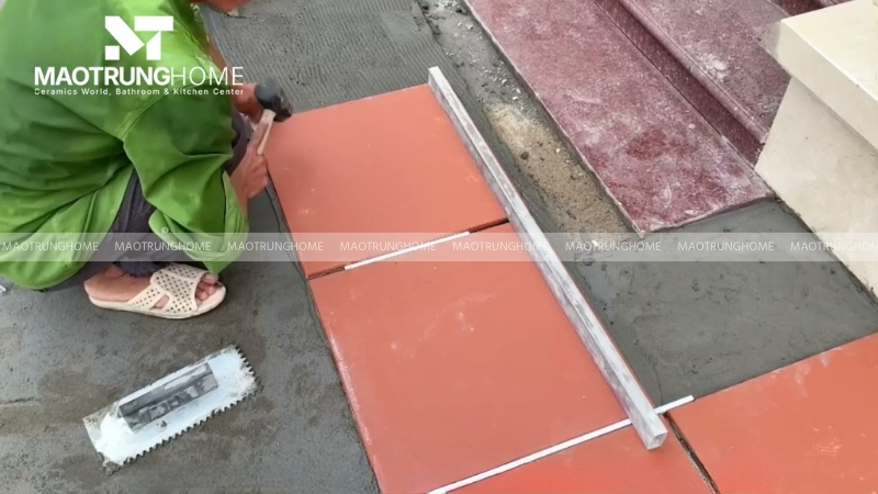 Đặt gạch lên lớp vữa, dùng búa cao su gõ nhẹ để gạch bám chắc và tạo độ phẳng