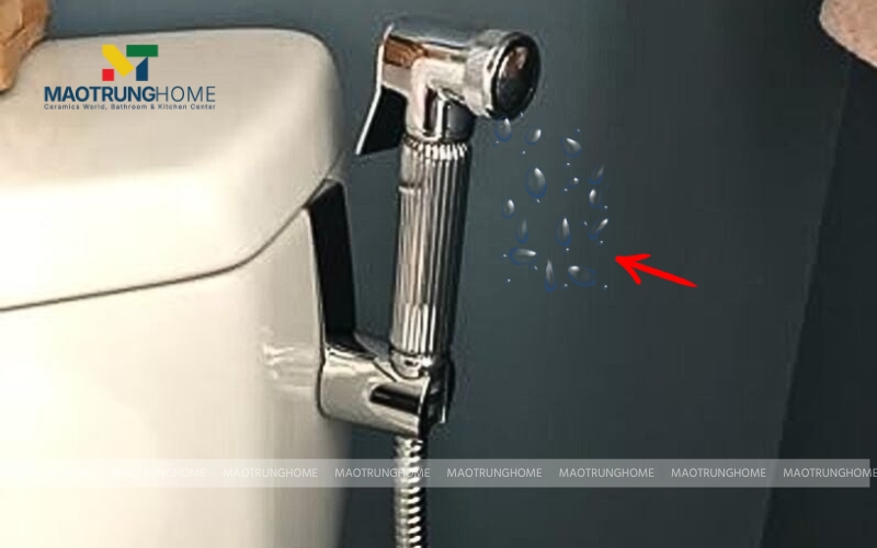 Đầu vòi xịt đang nhỏ giọt nước xuống sàn