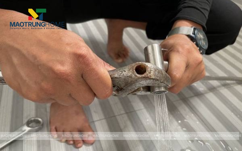 Thợ đang sửa mối nối của vòi xịt