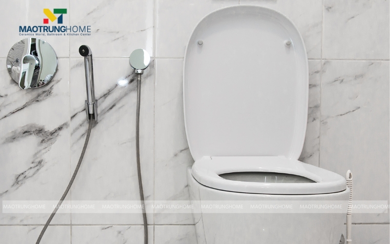 Vòi xịt vệ sinh được treo gọn gàng trên giá đỡ